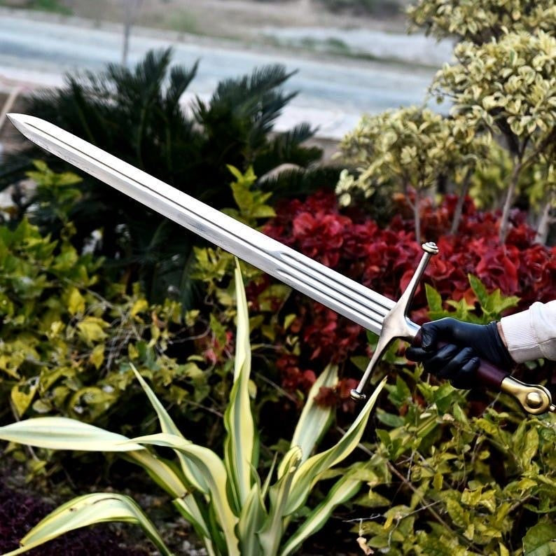 Wonder Woman God Killer Sword replica with golden dual-dragon hilt and etched Amazonian runes on a polished steel blade.